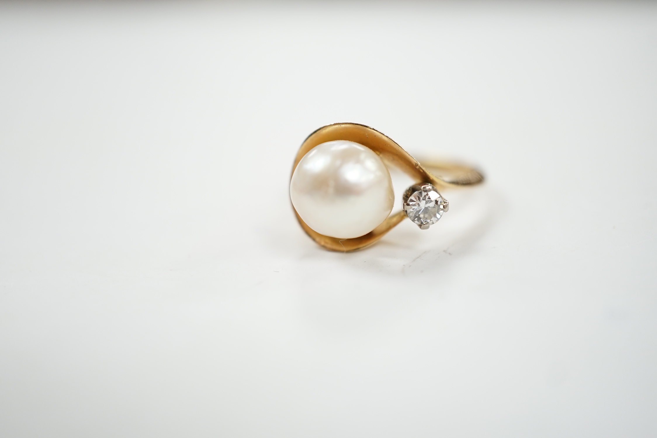 A yellow metal , single stone cultured pearl and single stone diamond set ring, size J, gross weight 4.8 grams.